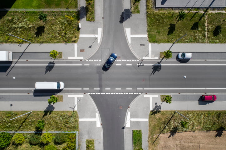 An Aerial View Of An Intersection With Vehicles On The Road. 