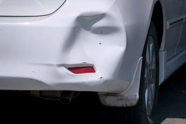 Damage to a car bumper after a hit-and-run accident.